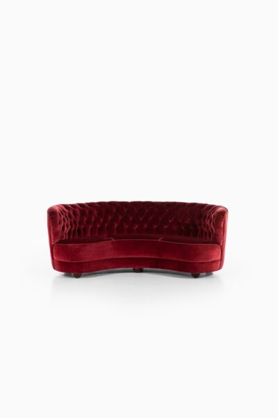 Large freestanding curved sofa in red velvet at Studio Schalling