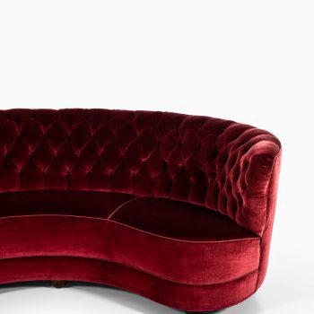 Large freestanding curved sofa in red velvet at Studio Schalling
