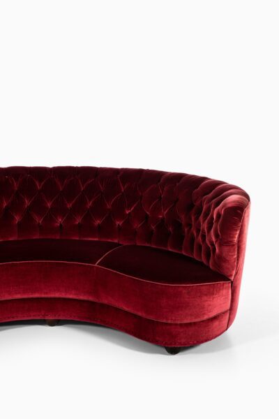 Large freestanding curved sofa in red velvet at Studio Schalling