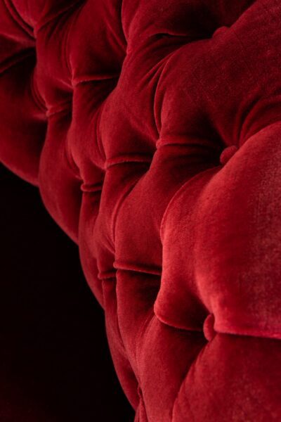 Large freestanding curved sofa in red velvet at Studio Schalling