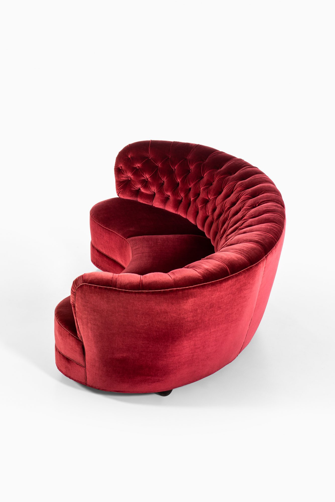 Large freestanding curved sofa in red velvet at Studio Schalling