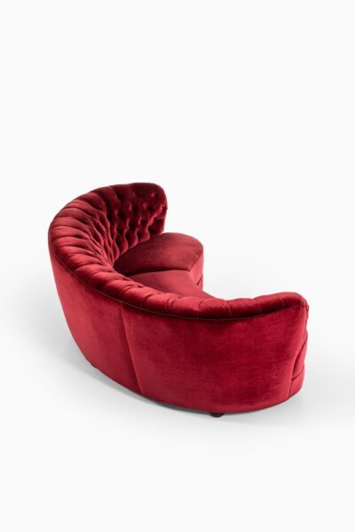 Large freestanding curved sofa in red velvet at Studio Schalling