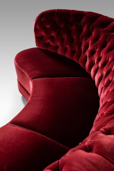 Large freestanding curved sofa in red velvet at Studio Schalling