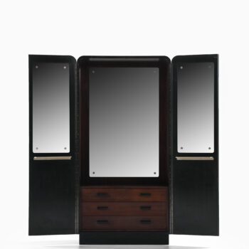 Black lacquered wood cabinet with brass pulls at Studio Schalling