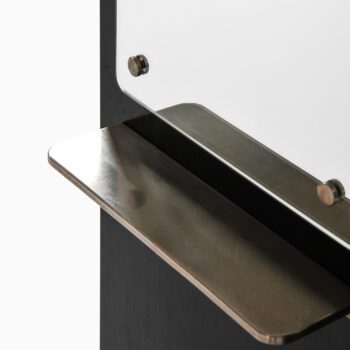 Black lacquered wood cabinet with brass pulls at Studio Schalling